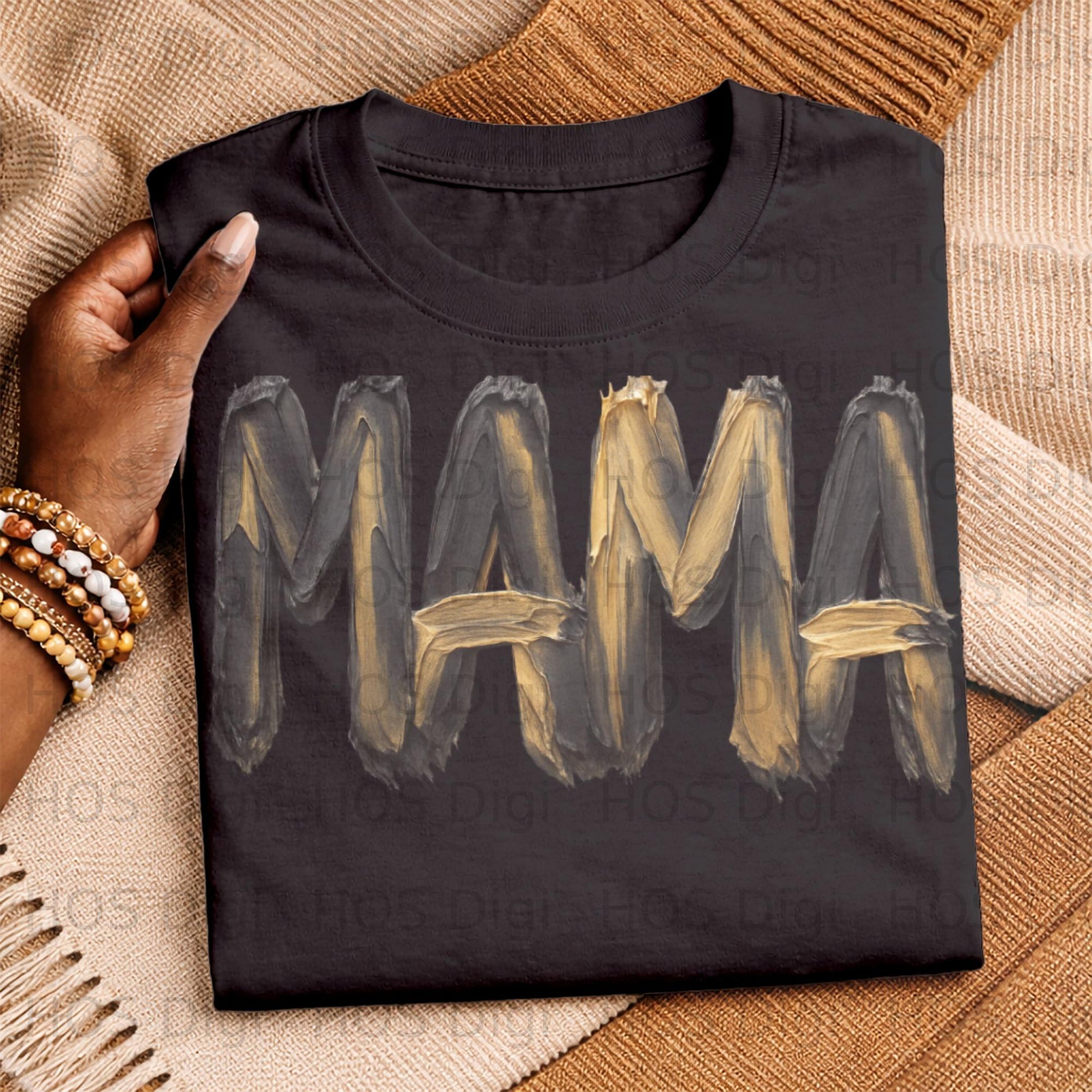 Black t-shirt with "MAMA" painted in thick gold and black brushstrokes.