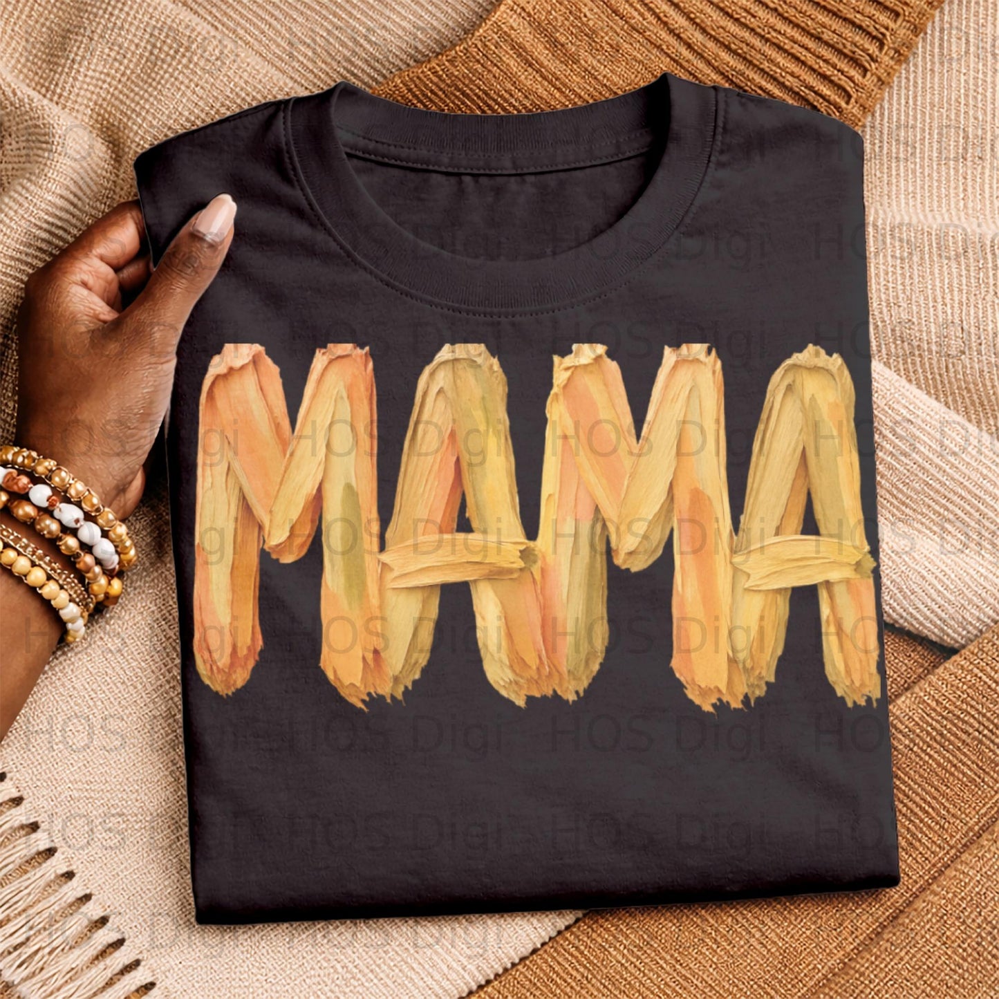 Black t-shirt with "MAMA" in textured orange and yellow brushstrokes.