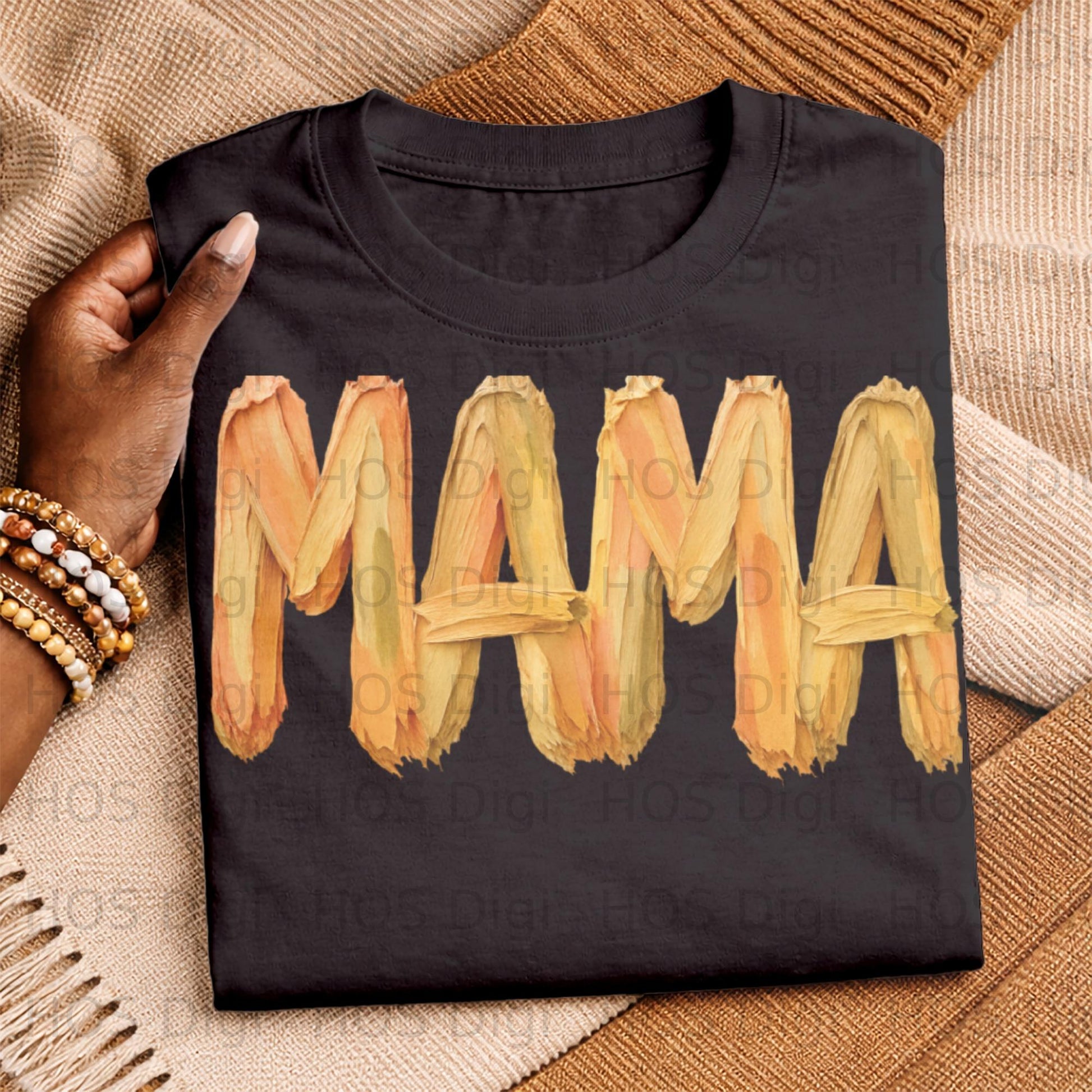 Black t-shirt with "MAMA" in textured orange and yellow brushstrokes.