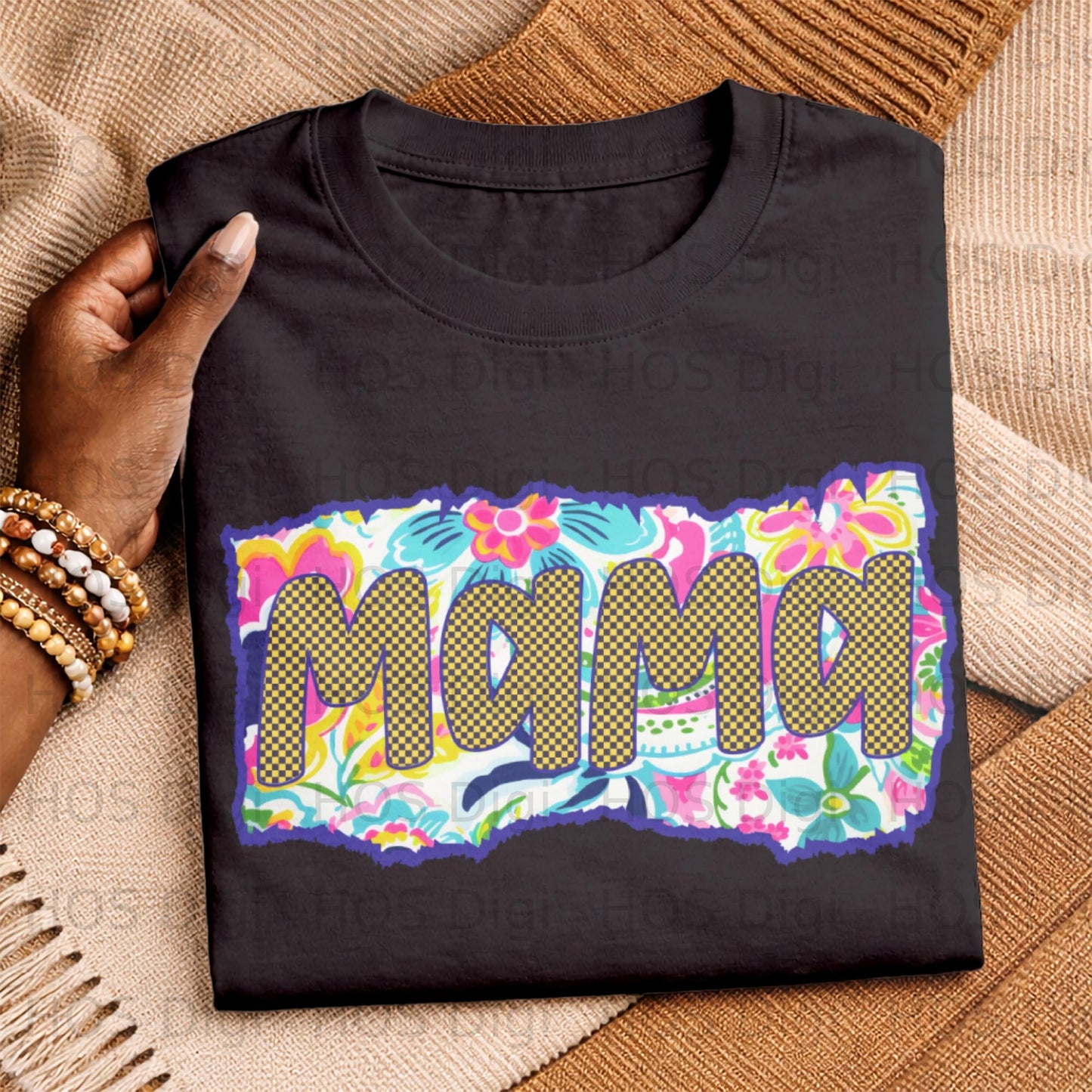 Black t-shirt with "Mama" in colorful floral and checkered pattern.