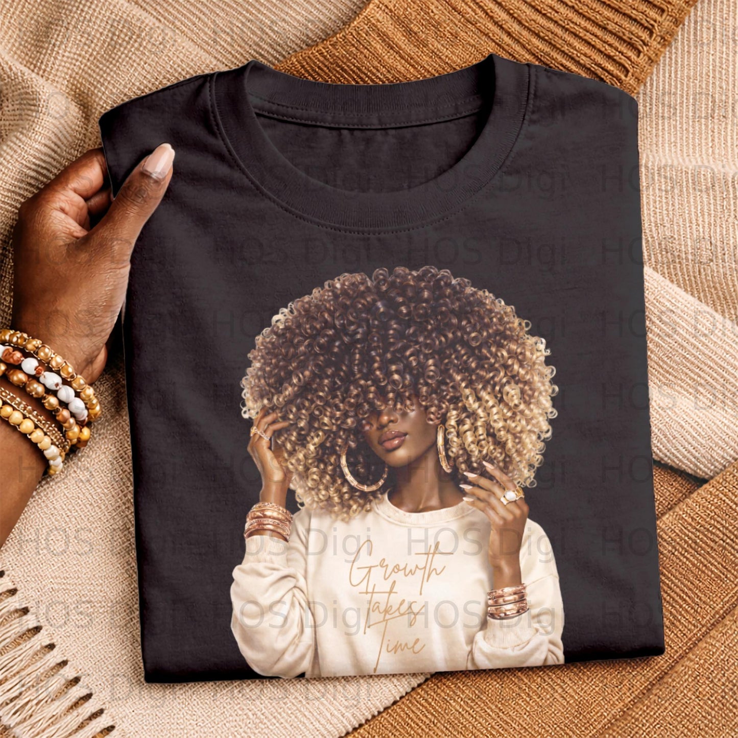 Black t-shirt with woman wearing a cream sweatshirt and large blonde curly hair.